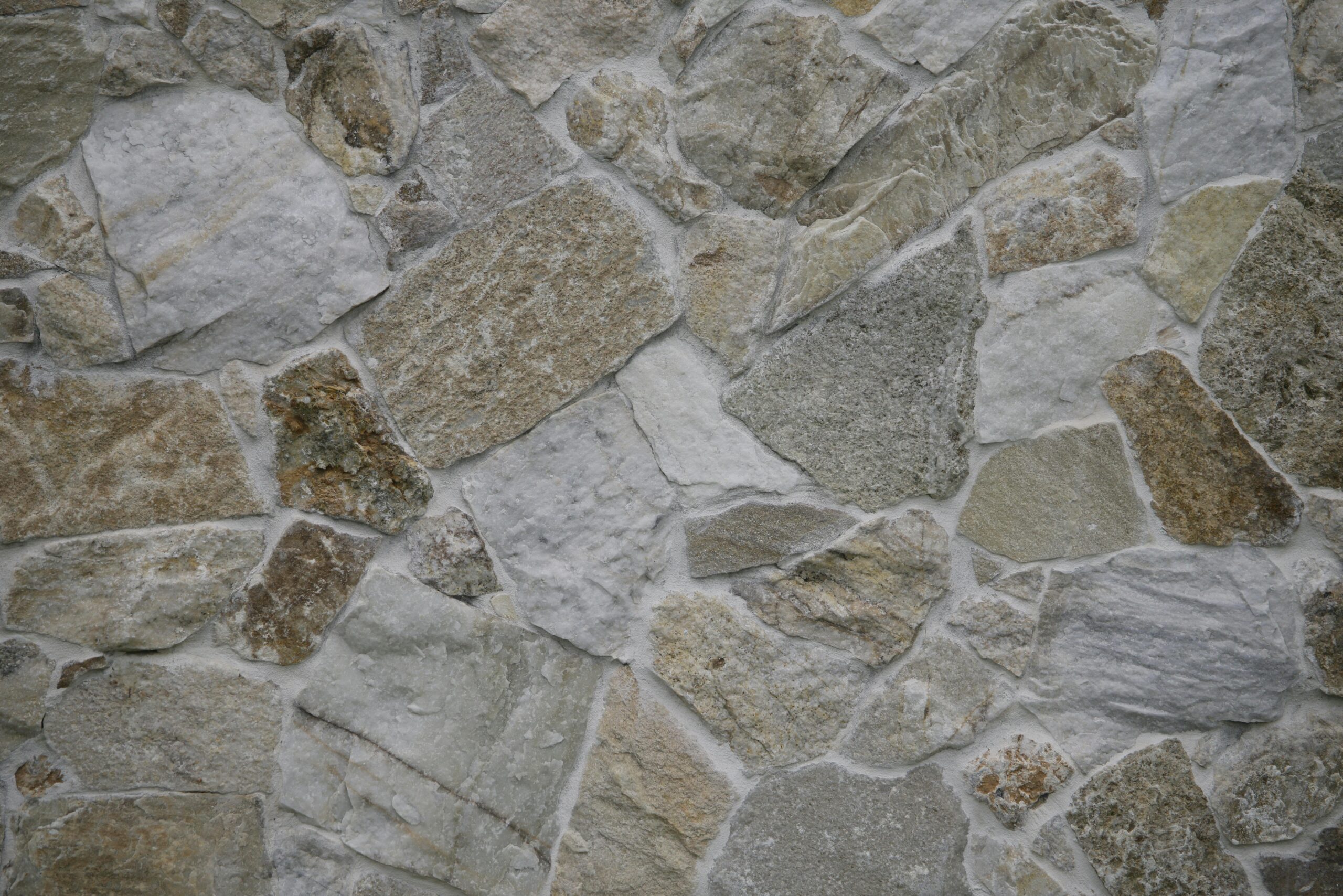 Close-up of a textured stone wall, featuring natural patterns and varied shades.